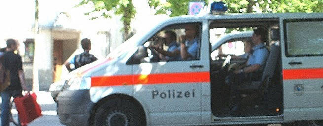Stadtpolizei Zürich. Einer beobachtet mit dem Feldstecher die Frauen an der Frauendemo 2008. 
